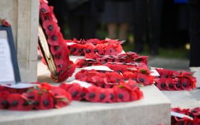 Poppy wreaths on base of war memorial.