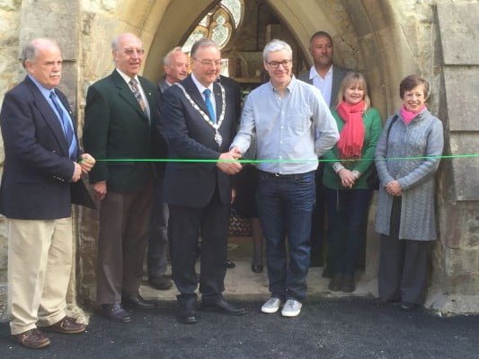 People cutting a ribbon to open building. 