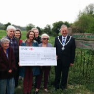 Group of people and the Mayor holding large cheque.