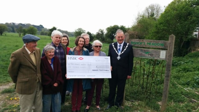 Group of people and the Mayor holding large cheque.