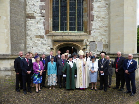 Mayors, guests and Bishop in a group outside church.