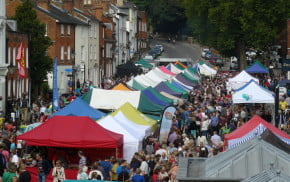 Brightly coloured marquees in street and crowds of people