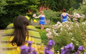 Two female dancers in the background with a child dressed as a bee in the foreground