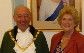 Male and female stood in front photo of the Queen