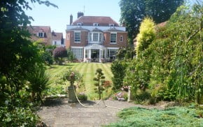 View of period house with beautiful garden in front