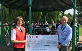 A female and male holding a large cheque for £1000.