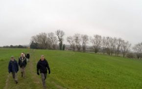 People in field with trees in background. Winter scene