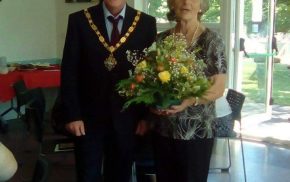 Mayor presenting female with a bouquet of flowers.