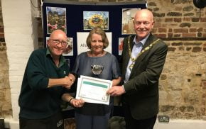 Female being presented with a certificate by the Mayor and a male.