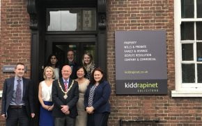 Group of people with Mayor standing outside an office.