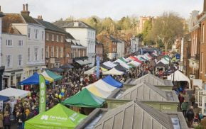 Aerial view of a crowded market with people and marquees.