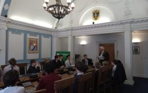 School children sitting around a conference table.