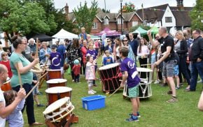 Taiko drummers watched by a crowd of people