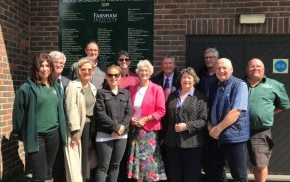 Group of people standing in front of a sign.