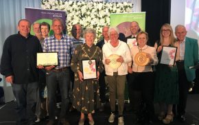 Group of people holding certificates and trophies