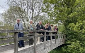 Group of people standing on a wooden bridge