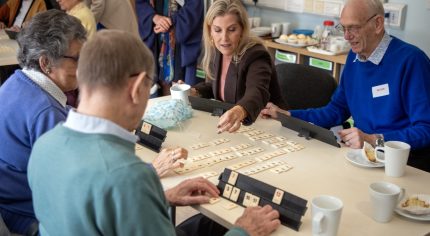 Four people playing a board game.