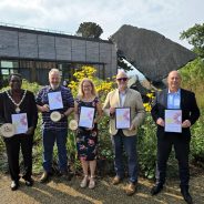 Five people holding certificates