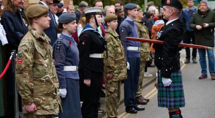 Uniformed cadets stand before parade marshall at Remembrance Sunday parade.