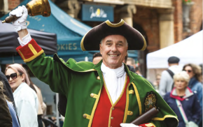 Front cover of a residents' guide showing a town crier.